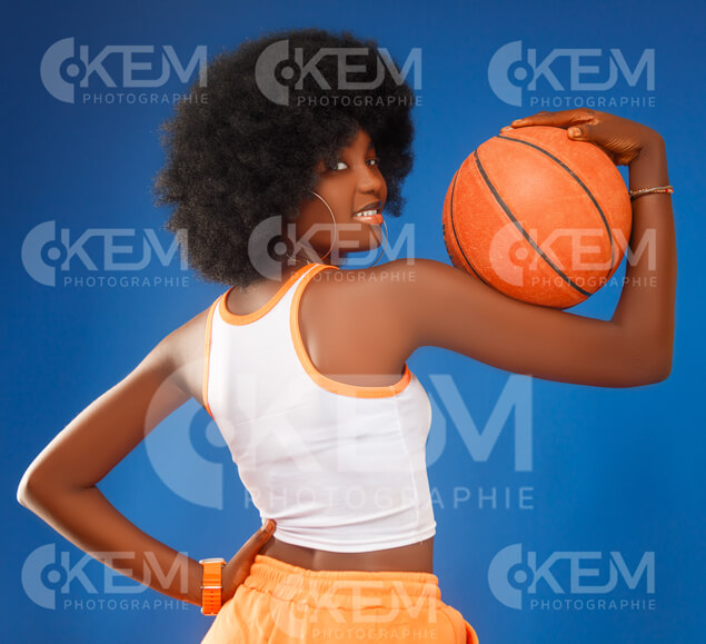 jeune-fille-en-mode-pantalon-jogging-orange-haut-blanc-debout-avec-un-ballon