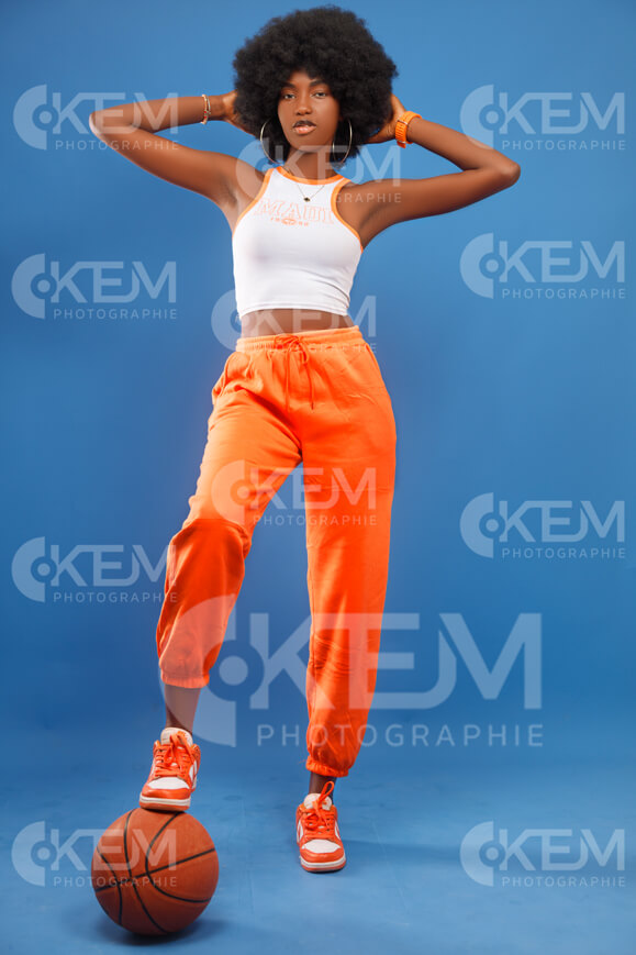 jeune-femme-en-mode-lifestyle-avec-un-ballon-de-basket-pantalon-jogging-orange-avec-haut-blanc