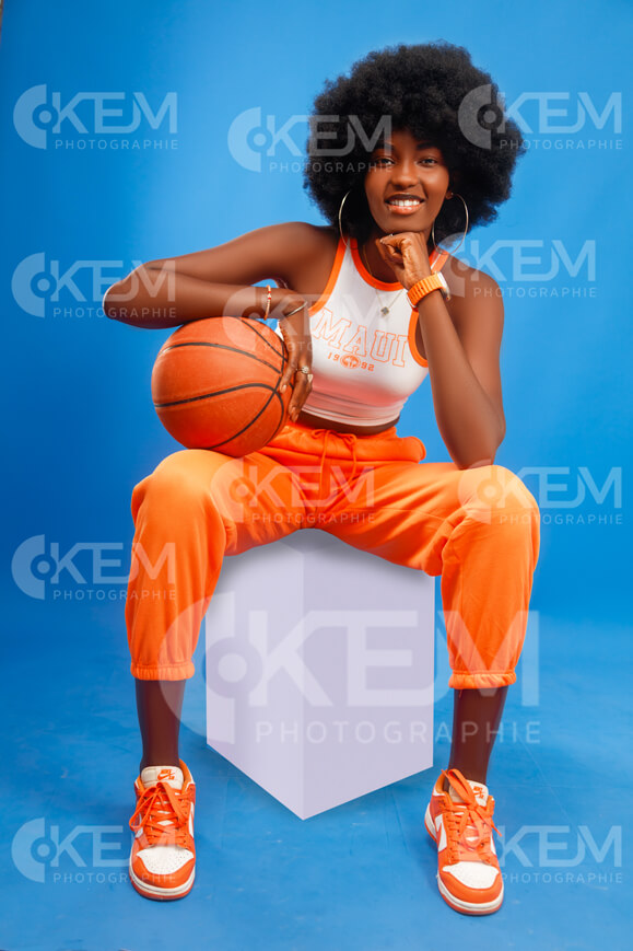 jeune-fille-en-mode-pantalon-jogging-orange-haut-blanc-et-des-baskets-assise